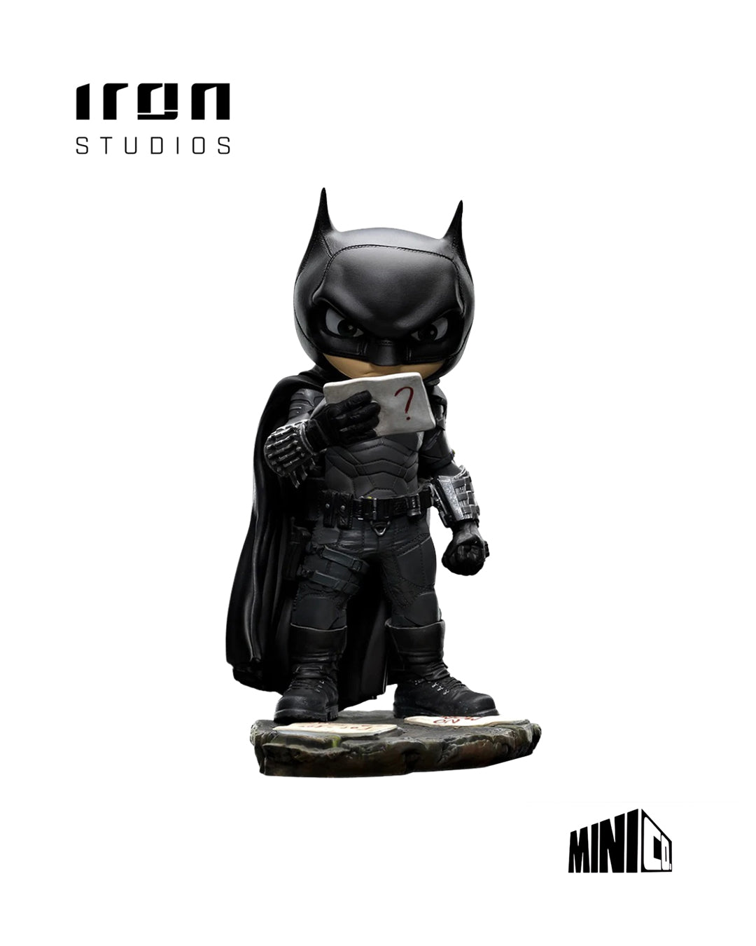 Estatua MiniCo de Batman: figura estilizada del Caballero Oscuro en su traje táctico negro, con capa y máscara, sosteniendo una pista en la mano. Base con papeles y pistas, representando su faceta de detective. Pintada a mano, fabricada en PVC.